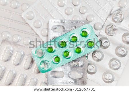 Used Green Capsules and pills packed in blisters