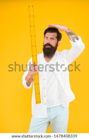 Small little big large. Does size really matter. One meter. Man bearded hipster holding ruler. Measure length. Size tall and length. Big size. Measure. Geometry theorem. Actual size. School teacher. 商業照片 © 