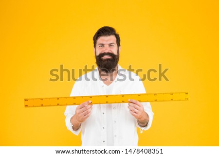Size tall and length. Big size. Measure and control. Geometry theorem. Actual size. School teacher. Small little big large. Does size really matter. Man bearded hipster holding ruler. Measure length. 商業照片 © 