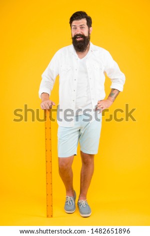 Actual size. School teacher. Small little big large. Does size really matter. One meter. Man bearded hipster holding ruler. Measure length. Size tall and length. Big size. Measure. Geometry theorem. 商業照片 © 