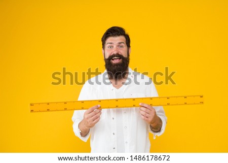 Actual size. School teacher. Small little big large. Does size really matter. Man bearded hipster holding ruler. Measure length. Size tall and length. Big size. Measure and control. Geometry theorem. 商業照片 © 