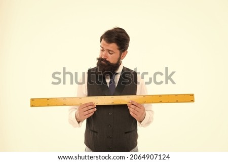 Size table concept. Learning metric system. School teacher. Size really matters. Man bearded hipster holding ruler. Measure length. Measure and control. Geometry theorem. Measure with centimeters 商業照片 © 