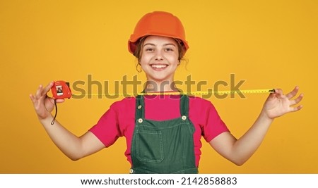 This will be perfect. kid wear helmet on construction site. teen girl builder with building tool tape measure. child on repairing work. concept of renovation in workshop. busy professional carpenter Photo stock © 