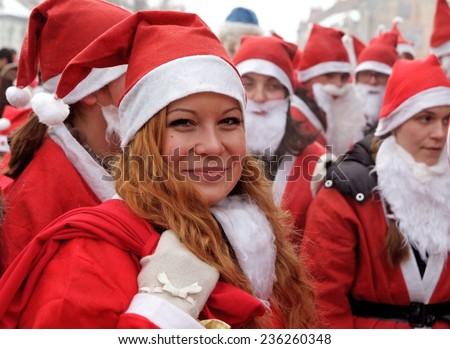 Uzhgorod,Ukraine-December 17, 2010: Smiling girl dressed as a Santa Clause in the front of group of other people dressed the same during Santa Claus parade December 17, 2010 in Uzhgorod, Ukraine