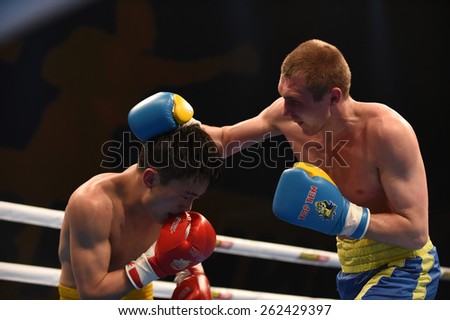 Kyiv, UKRAINE - March 20, 2015 : PRUDKYI Oleg (UA) and SHAN Jun (China)  in the ring during boxing fight Ukraine Otamans vs China Dragons in Palace of Sport in Kiev, Ukraine