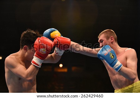 Kyiv, UKRAINE - March 20, 2015 : PRUDKYI Oleg (UA) and SHAN Jun (China)  in the ring during boxing fight Ukraine Otamans vs China Dragons in Palace of Sport in Kiev, Ukraine