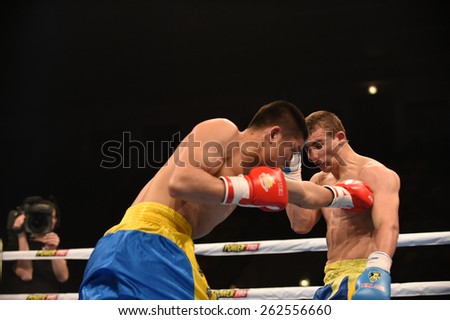 Kyiv, UKRAINE - March 20, 2015 : KHYZHNIAK Oleksandr (UA) and WANG ZHIBAO (China) in the ring during boxing fight Ukraine Otamans vs China Dragons in Palace of Sport in Kiev, Ukraine