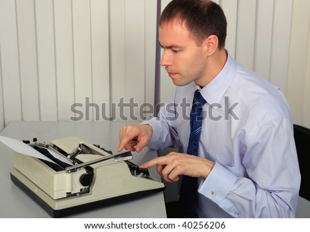 A businessman prints to the old printing typewriter.