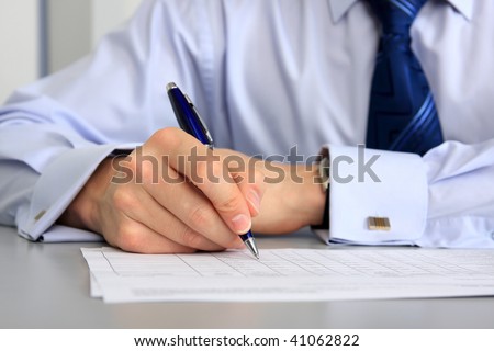 Hands of businessman with a pen and paper.