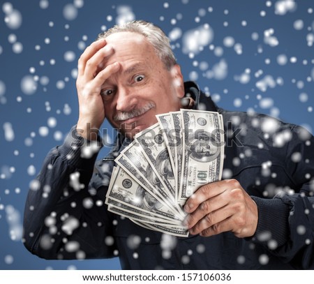 christmas, x-mas, sale, banking concept - Lucky old man holding group of dollar bills. Focus on money