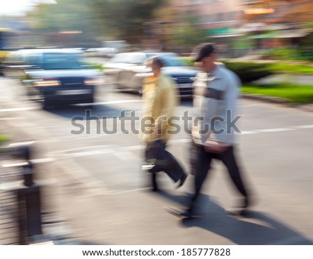 Group of people crossing the street at a crosswalk. Intentional motion blur