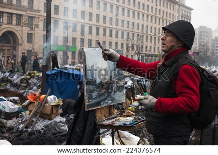 KIEV, UKRAINE - Feb 12, 2014: Mass anti-government protests in the center of Kiev. Barricades, ruin and chaos on Hrushevskoho St. Artist making sketches on the barricades