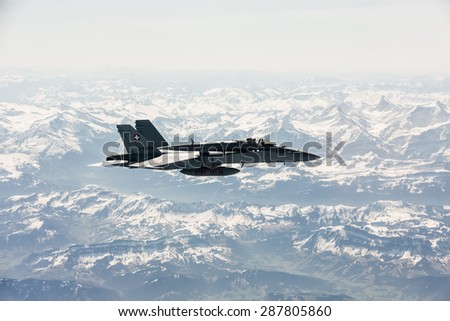 ALPS, SWITZERLAND - Apr 21, 2015: F-18 fighter jet of Swiss military air force on combat duty in the skies over Switzerland in the area of the Swiss Alps