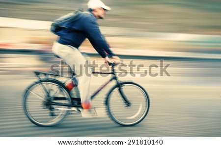 Abstract image of cyclist on the city roadway. Intentional motion blur and color shift