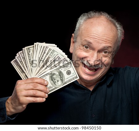 An elderly happyl businessman showing fan of money