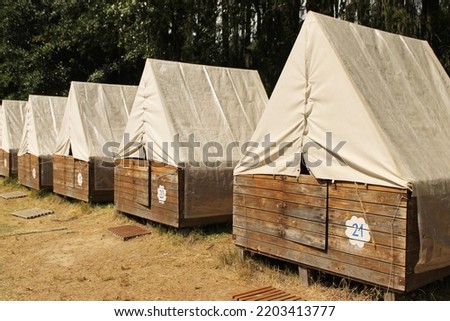 Tents at a children's summer camp in the Czech republic. Wooden tents with wooden door and light celts as a roof. Tents in the line. Perspective. Little wooden houses for summer camping in a forest. Photo stock © 