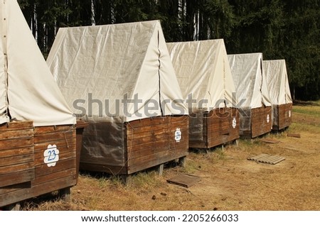 Tents at a children's summer camp in the Czech republic. Wooden tents with wooden door and light celts as a roof. Tents in the line. Perspective. Little wooden houses for summer camping in a forest. Photo stock © 