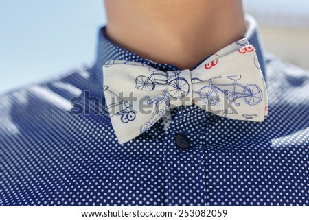 closeup of butterfly tie and blue shirt on caucasian man