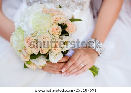 beautiful wedding bouquet of roses and eustoma flowers in hands of the bride