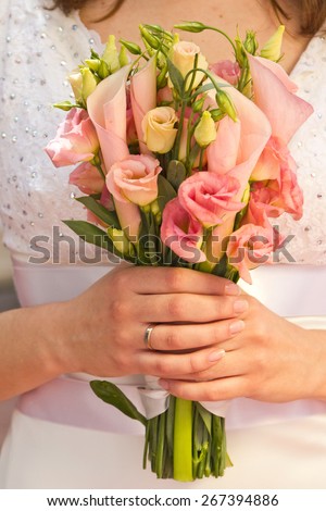 Beautiful wedding bouquet of calla and eustoma flowers in hands of the bride