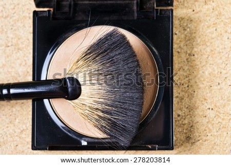 Makeup brush on a makeup powder, studio shot