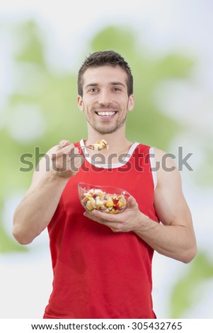 Man eating healthy fruit salad, smiling