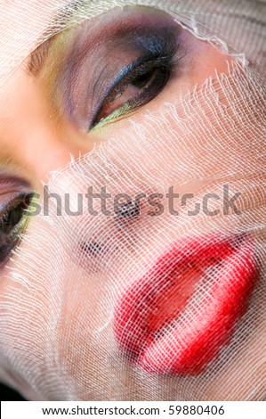 The woman\'s face with beautiful green eyes covered by a veil