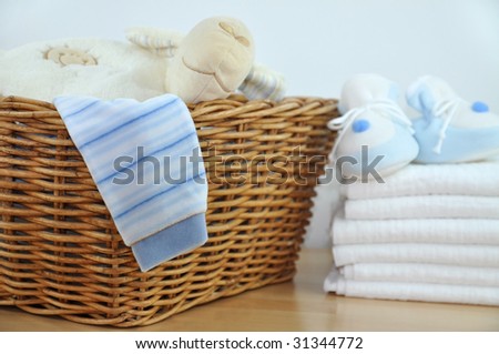 Laundry basket with blue clothes and slippers on a pile of diapers