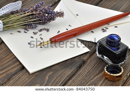 Fountain pen on empty letter with a bouquet of dried lavender on a wooden table