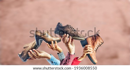 Hands holding different men and women shoes and boots. Concept of selection, purchase and repair of shoes. 商業照片 © 