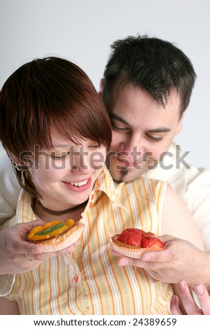 young man giving two cakes to his girlfriend