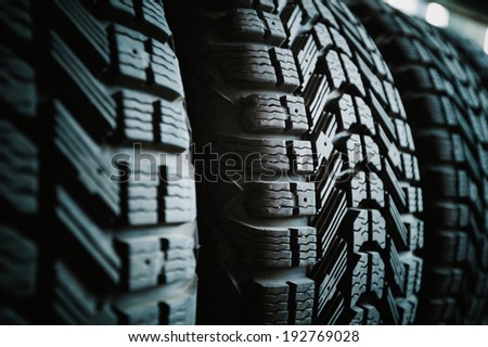 Car tires in a row on a shelf tire