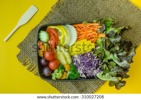 Healthy food. Fresh green salad on Yellow background, top view