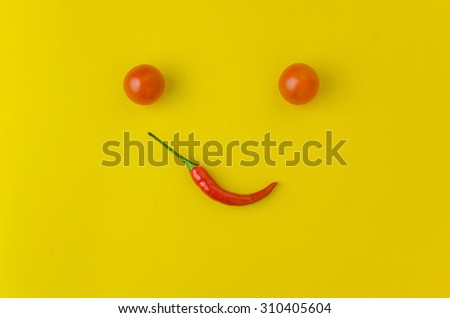 tomato and Chili  forming a smiley face isolated on Yellow