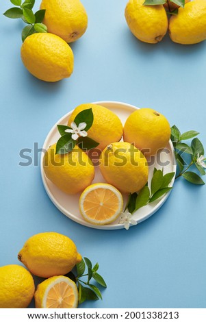 Ripe Yellow Lemons Close-up Background Or Texture. Lemon Harvest, Many Yellow Lemons.
Lemons Whole and sliced placed against a blue. Lemon in a white plate