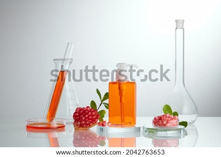 The blank bottle for cosmetics concept on empty podium with pomegranate extract. science bio skincare cream serum product with pomegranate extract.
