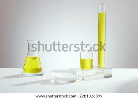 Similar – Image, Stock Photo Glass test tubes containing blue liquid on warm orange background.