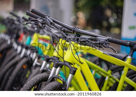 Many different bicycles in a row. Bicycles in the parking lot. Sale of bicycles. Bicycle rental.