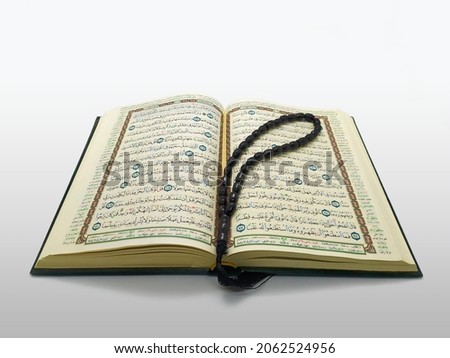 Opened Quran for Muslim to recites as a devotion to God with tasbeeh for zikir on it. Imagine de stoc © 