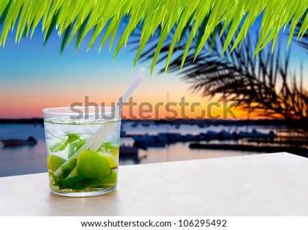 Cocktail Mojito in Balearic island sunset and palm trees [ photo-illustration]