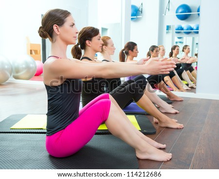 Aerobic Pilates personal trainer in a gym group class in a row