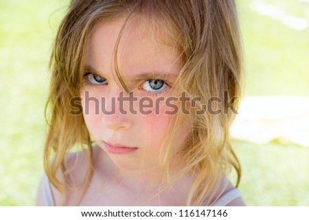 Angry blond children girl portrait looking at camera