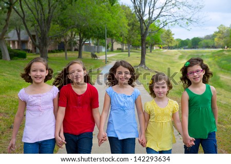 Children group of sisters girls and friends walking happy in the park outdoor