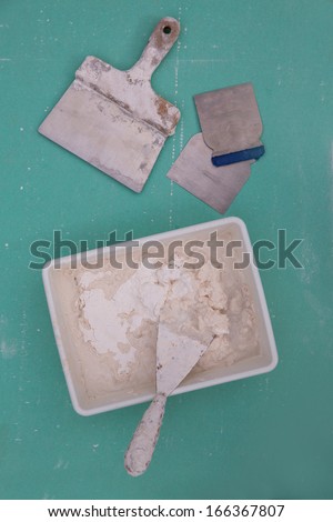 Plastering tools for plaster like plaste trowel spatula on green drywall plasterboard