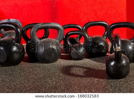 Kettlebells weights in a workout gym in red background