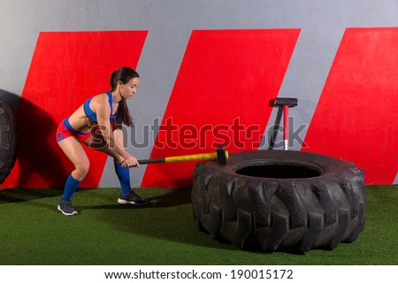 Sledgehammer Tire Hits woman workout at gym with hammer and tractor tire