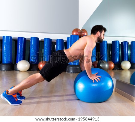 Fitball abdominal push ups Swiss ball man pushup at fitness gym