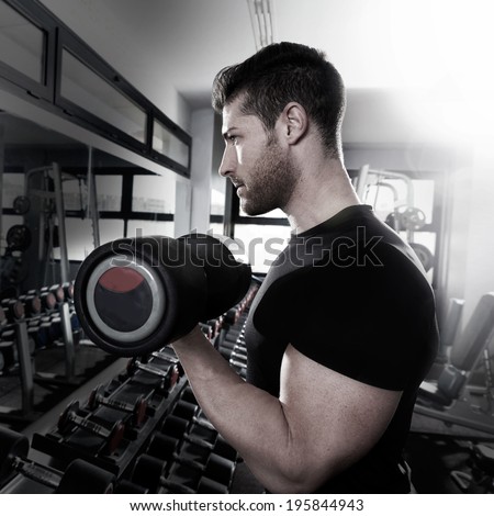 Dumbbell man at gym workout biceps fitness weightlifting