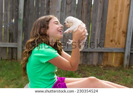 kid girl with puppy pet chihuahua playing happy with doggy outdoor