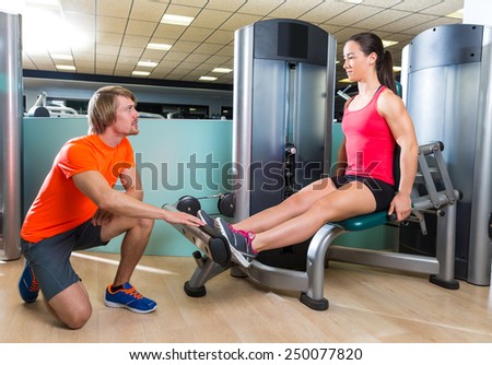 Calf extension woman at gym exercise machine workout and personal trainer woman